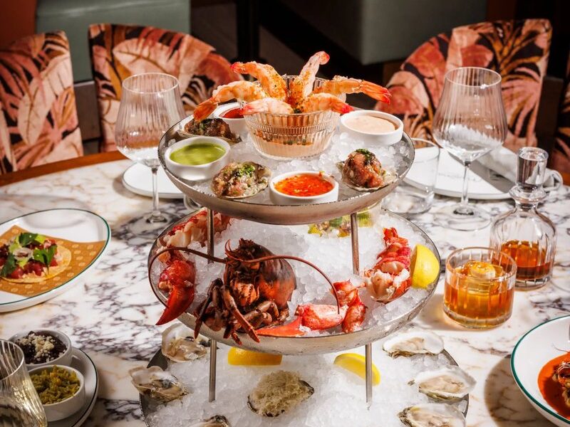 A marisco tower of chilled oysters, lobster and shrimp on a marble table